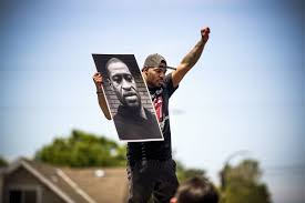 Man holding fist and George Floyd picture